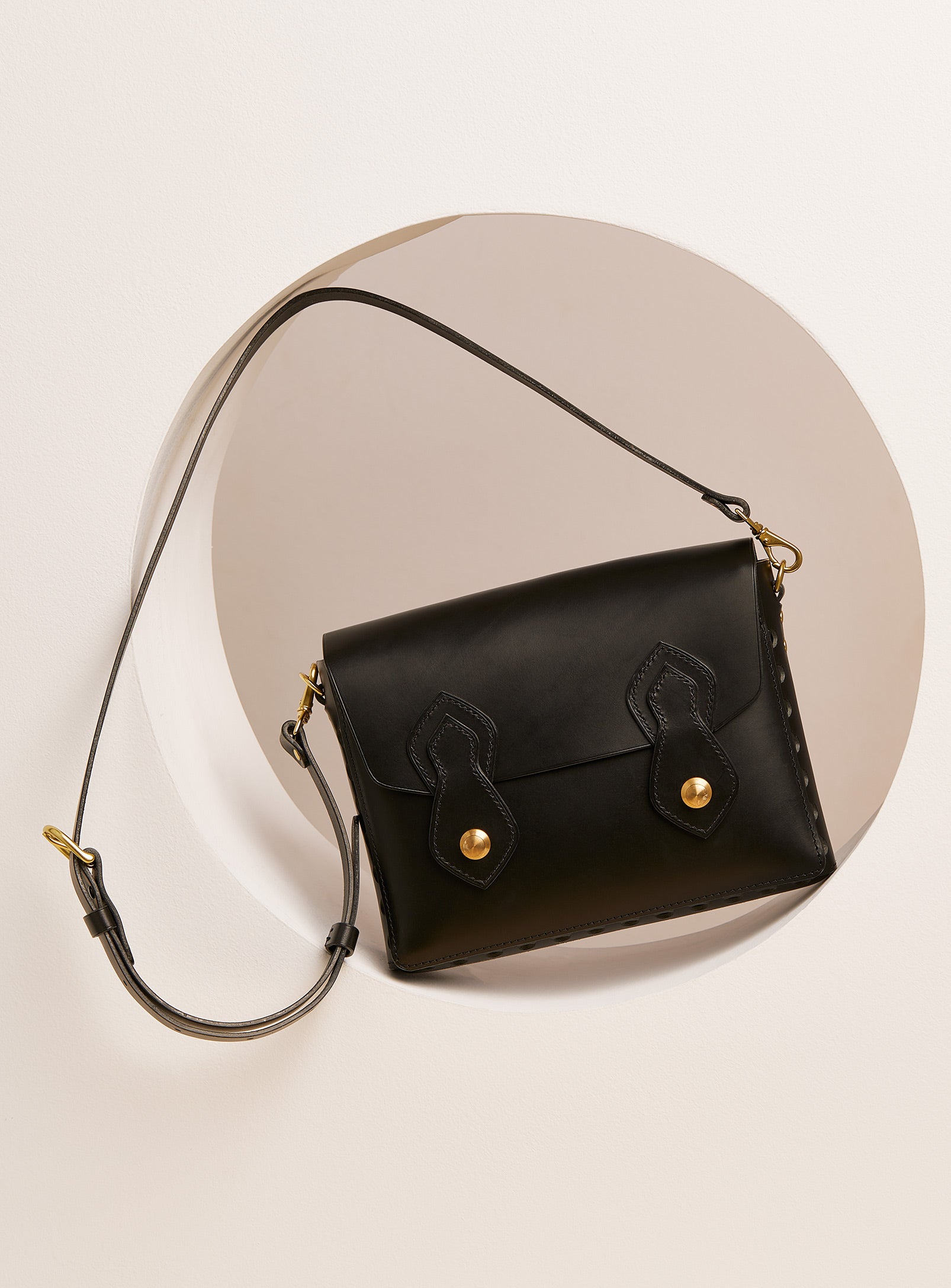 The modjūl odyssey bag in black. A large side bag with crossbody straps and double brass closure. Handcrafted in Canada using vegetable dyed Italian leather and quality brass hardware.