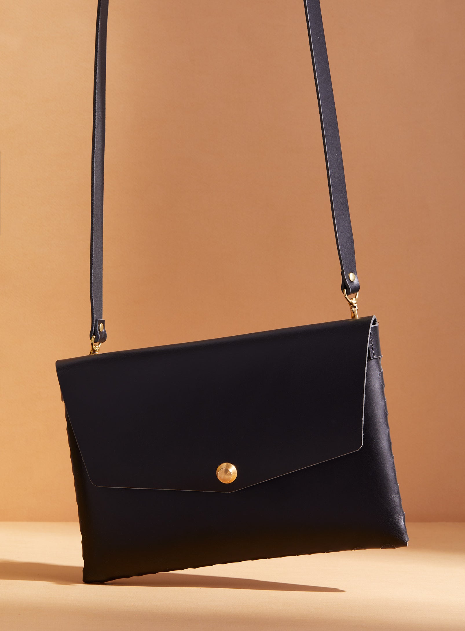 modjūl’s leather mini bag deluxe bag in black. A larger take on the classic mini bag, a rectangular-shaped bag with long detachable straps, handcrafted in Canada using quality Italian leather and brass hardware.