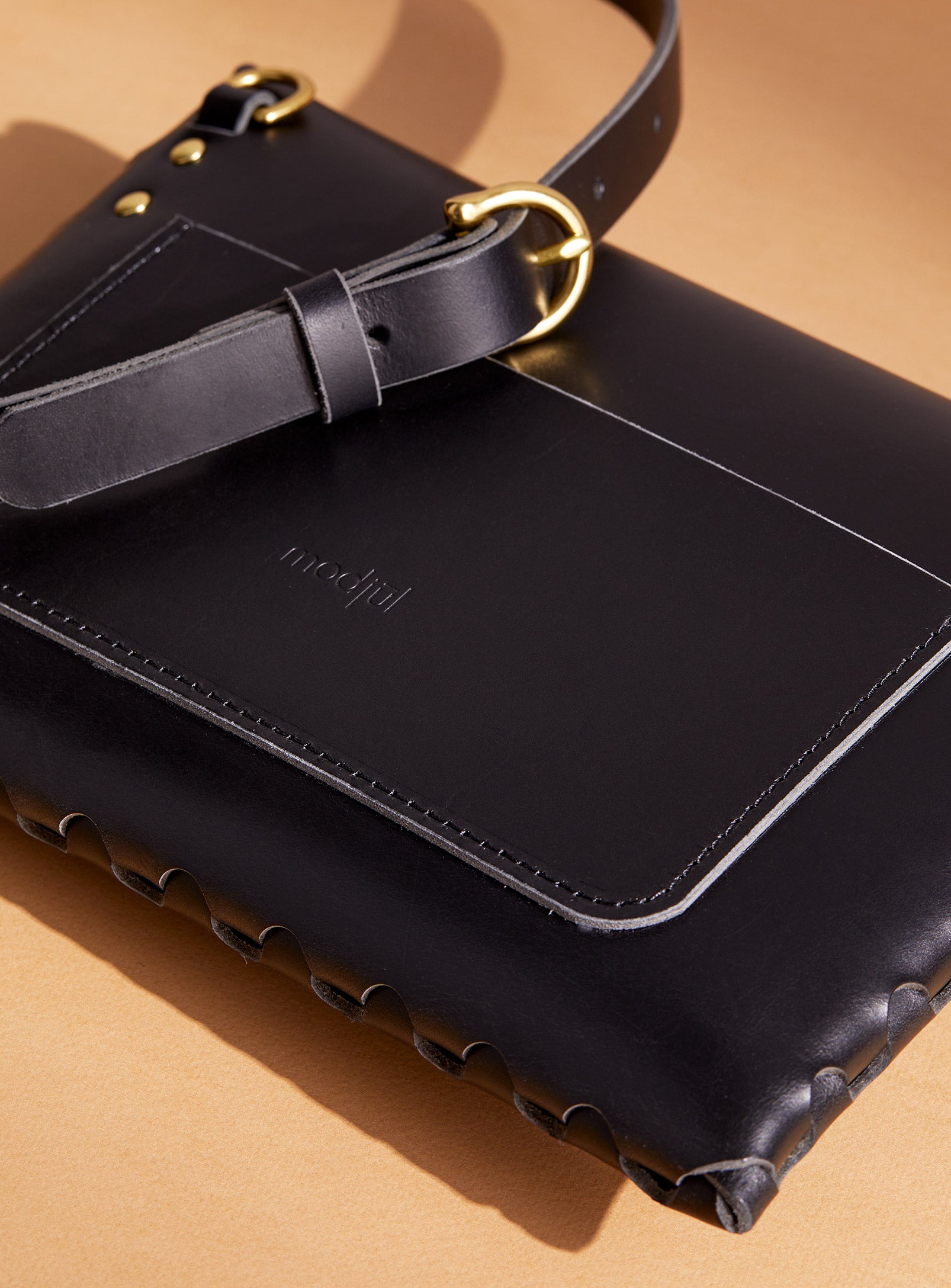 A close up of the back pocket detail on the mini bag deluxe handcrafted in Canada using black Italian leather and quality brass hardware.
