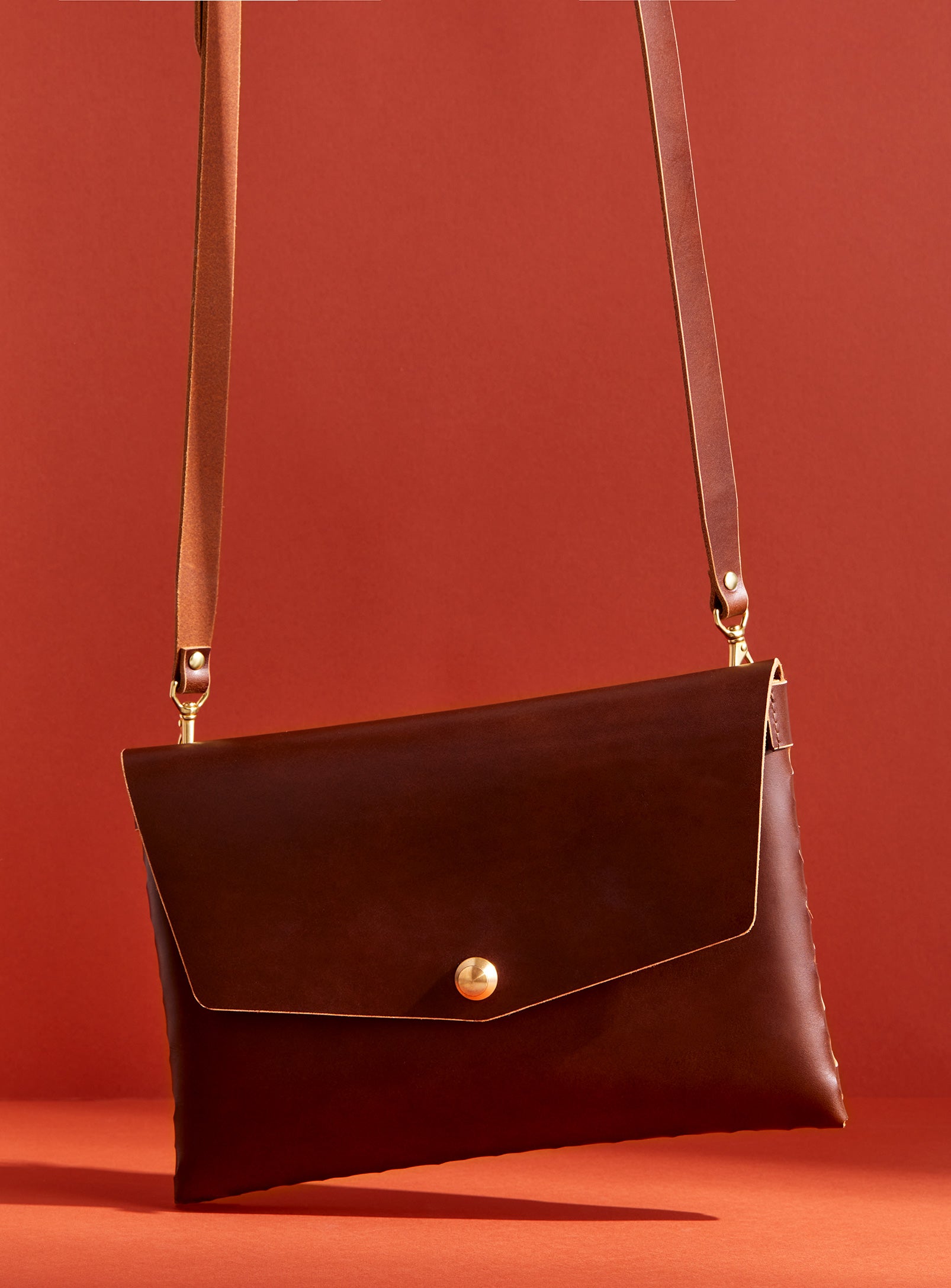 modjūl’s leather mini bag deluxe bag in brown. A larger take on the classic mini bag, a rectangular-shaped bag with long detachable straps, handcrafted in Canada using quality Italian leather and brass hardware.