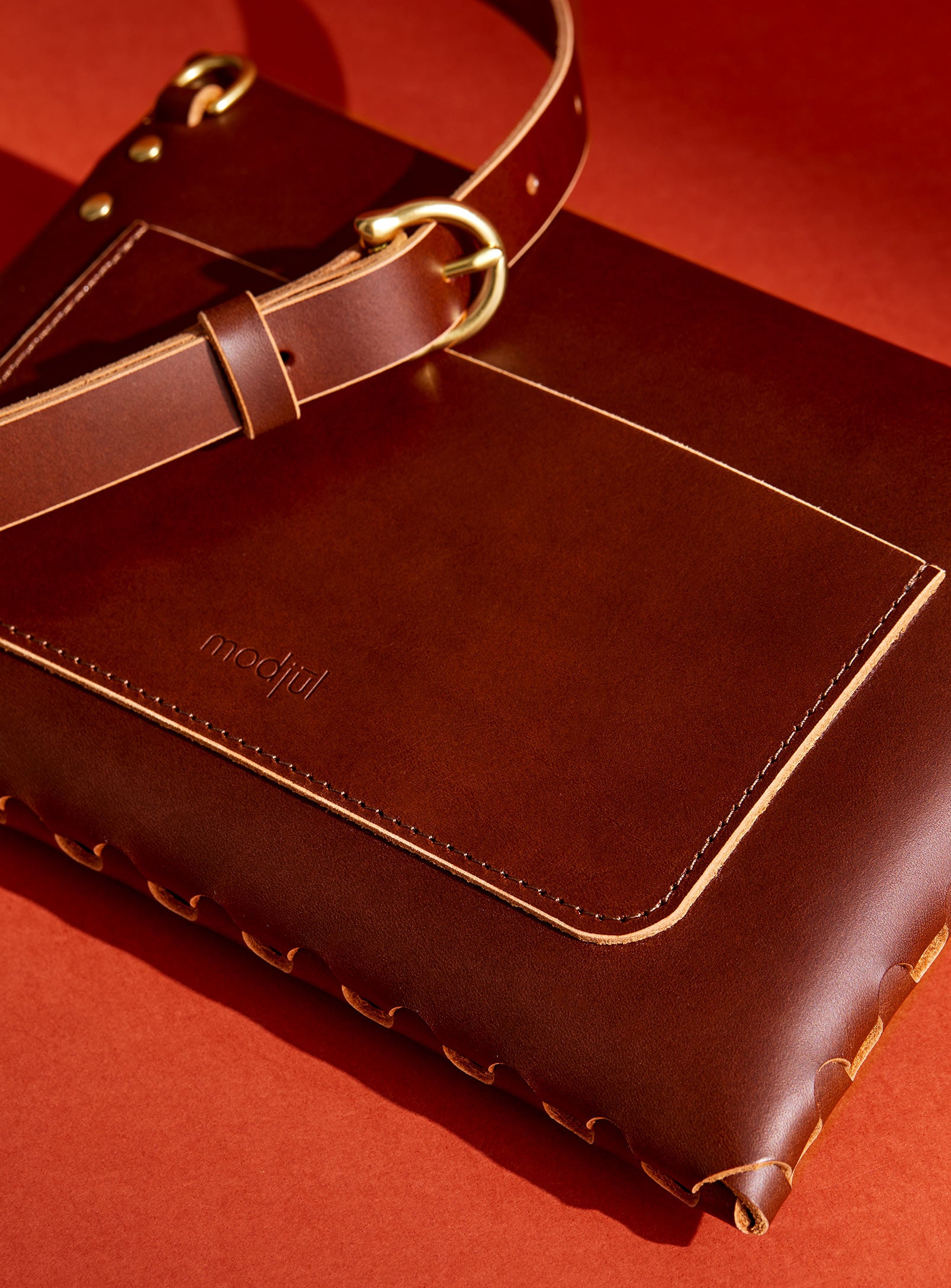 A close up of the back pocket detail on the mini bag deluxe handcrafted in Canada using brown Italian leather and quality brass hardware.