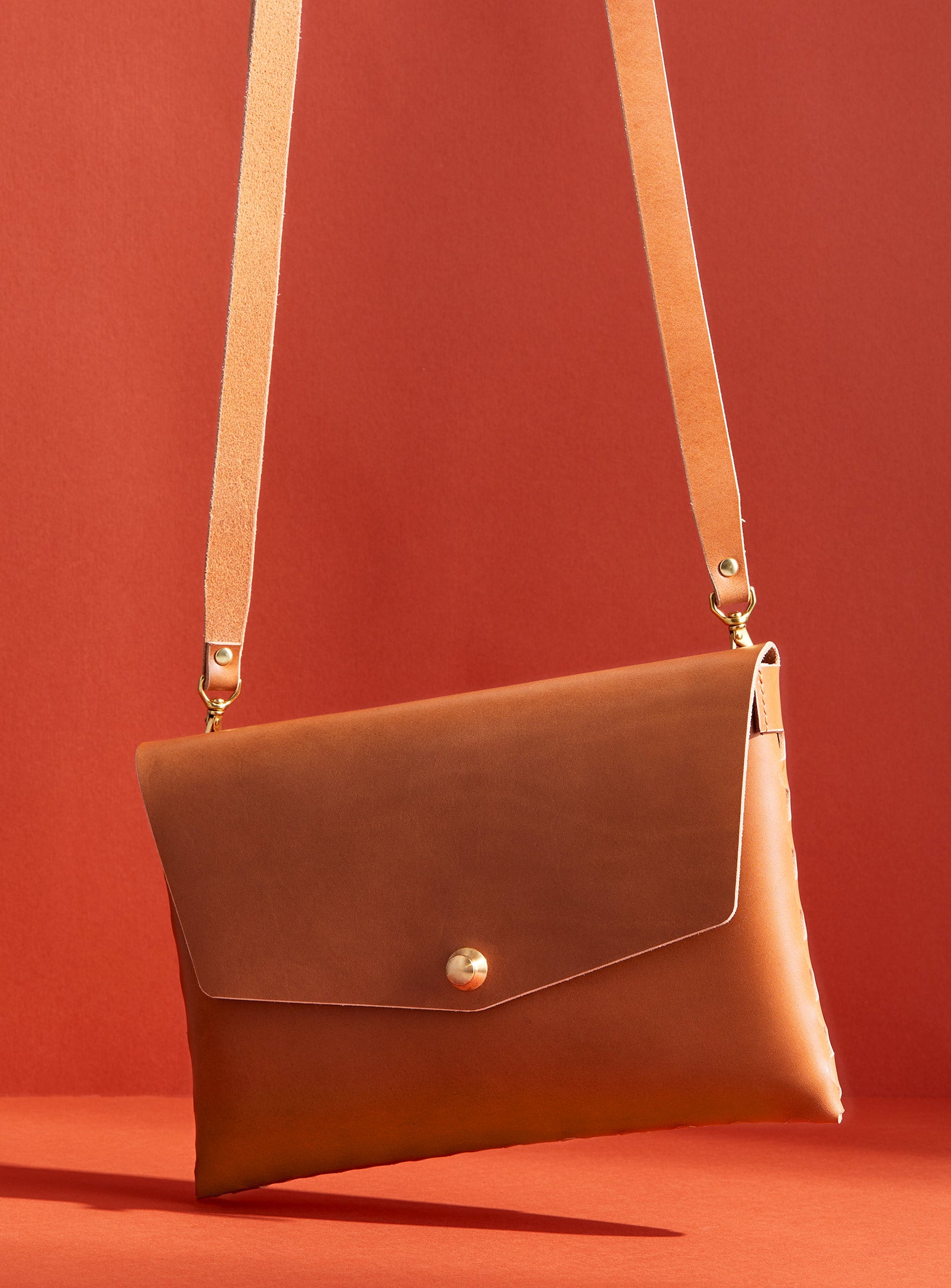 modjūl’s leather mini bag deluxe bag in camel. A larger take on the classic mini bag, a rectangular-shaped bag with long detachable straps, handcrafted in Canada using quality Italian leather and brass hardware.