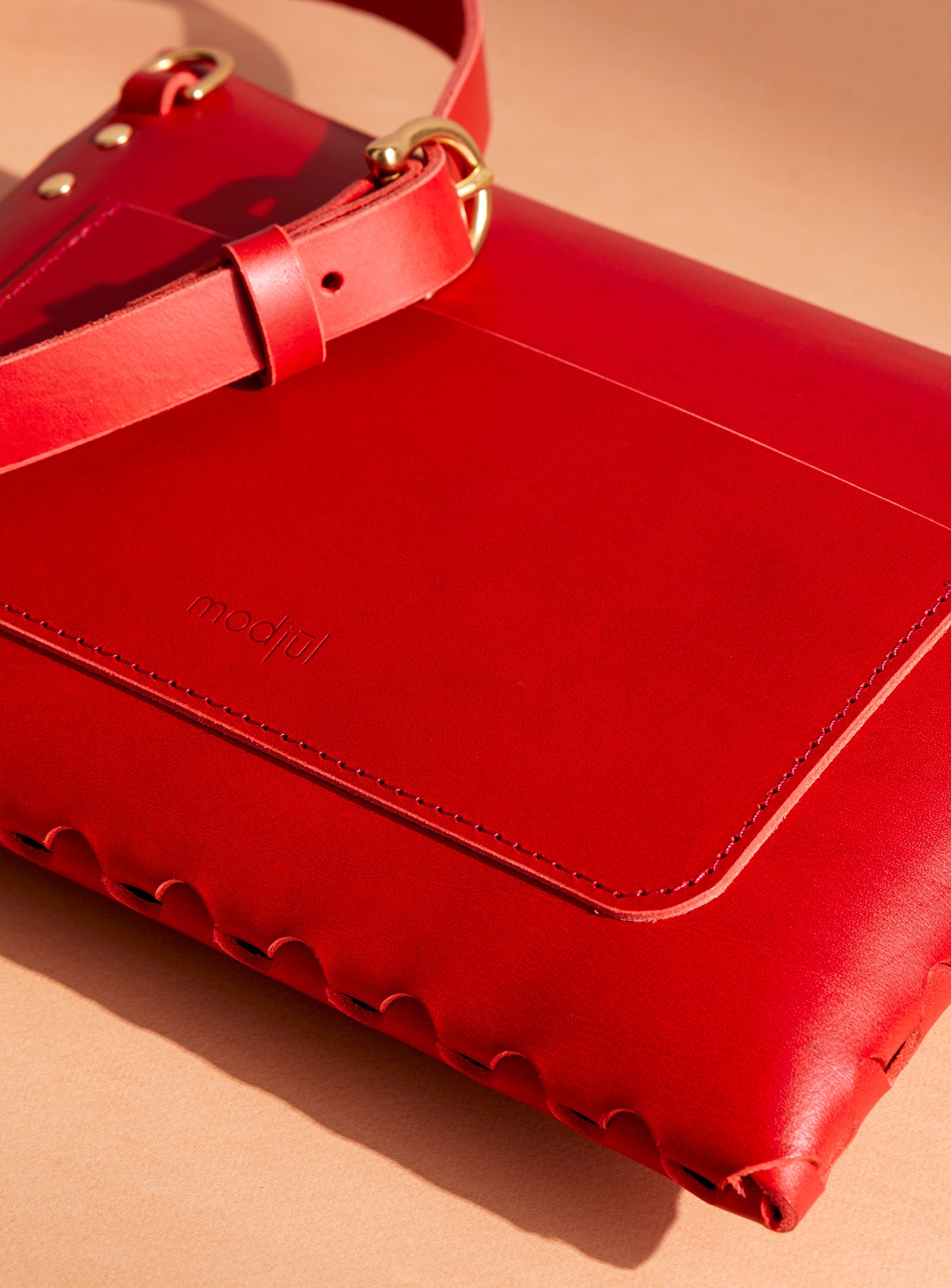 A close up of the back pocket detail on the mini bag deluxe handcrafted in Canada using red Italian leather and quality brass hardware.