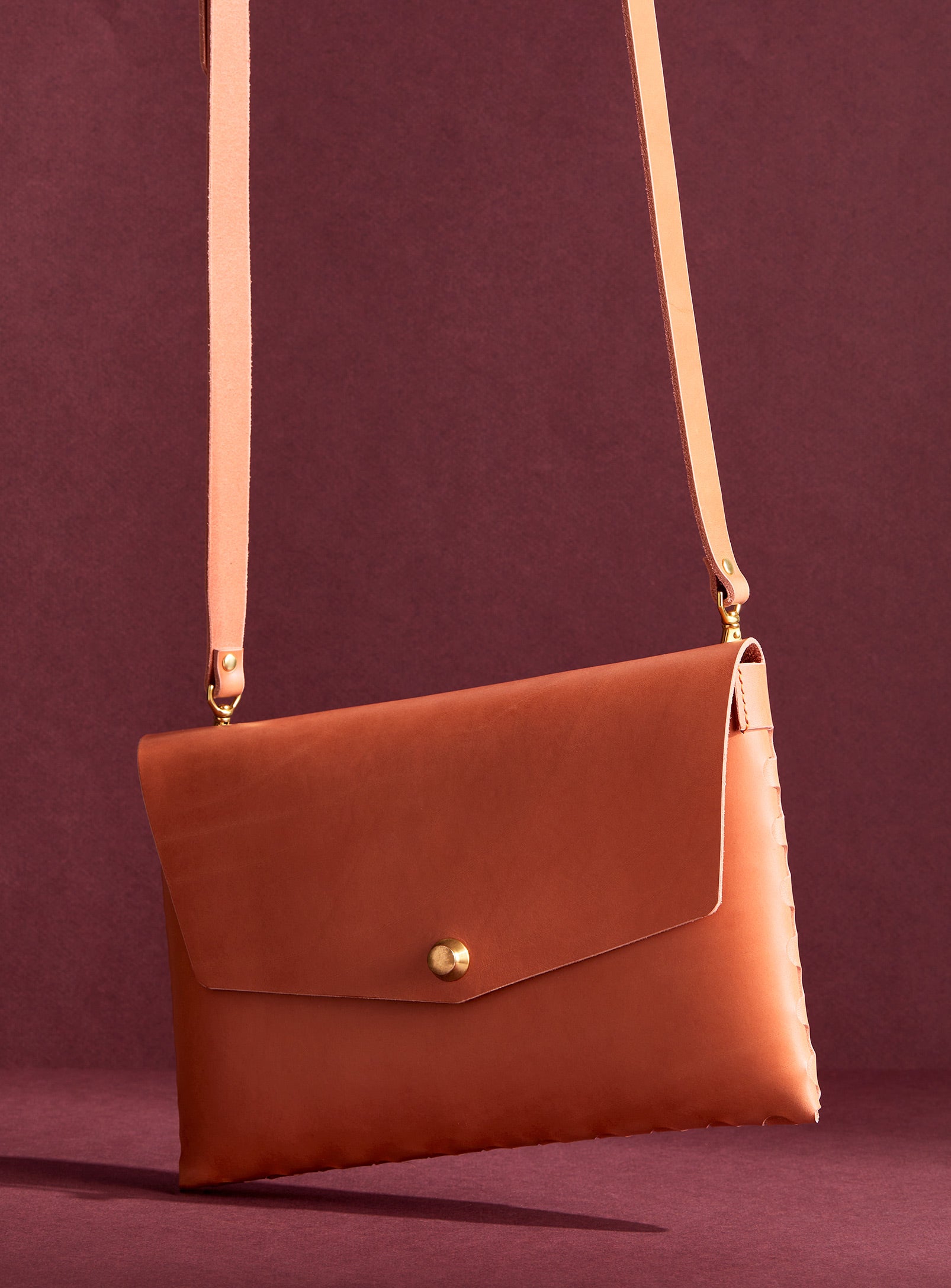 modjūl’s leather mini bag deluxe bag in pink. A larger take on the classic mini bag, a rectangular-shaped bag with long detachable straps, handcrafted in Canada using quality Italian leather and brass hardware.