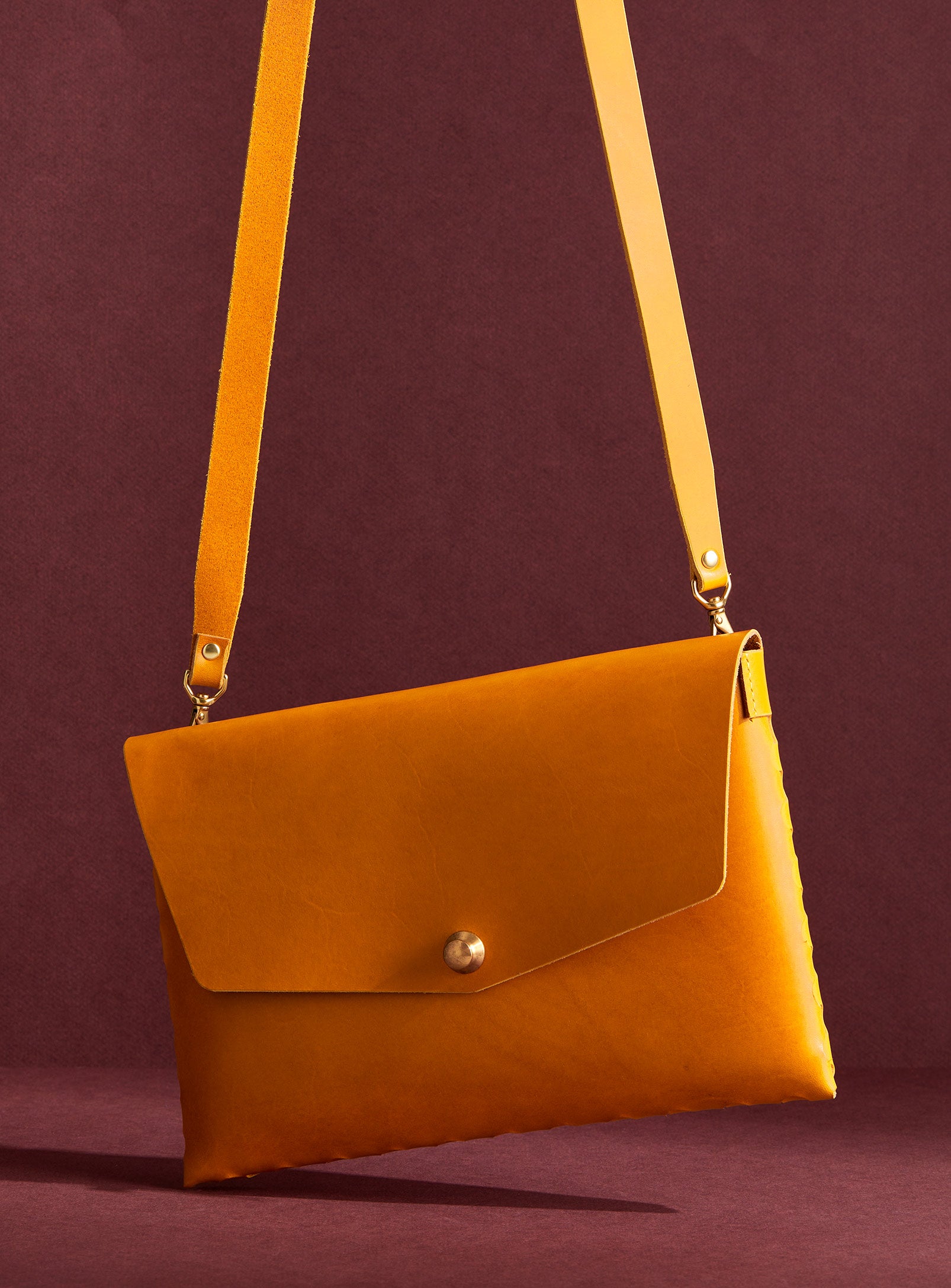 modjūl’s leather mini bag deluxe bag in yellow. A larger take on the classic mini bag, a rectangular-shaped bag with long detachable straps, handcrafted in Canada using quality Italian leather and brass hardware.