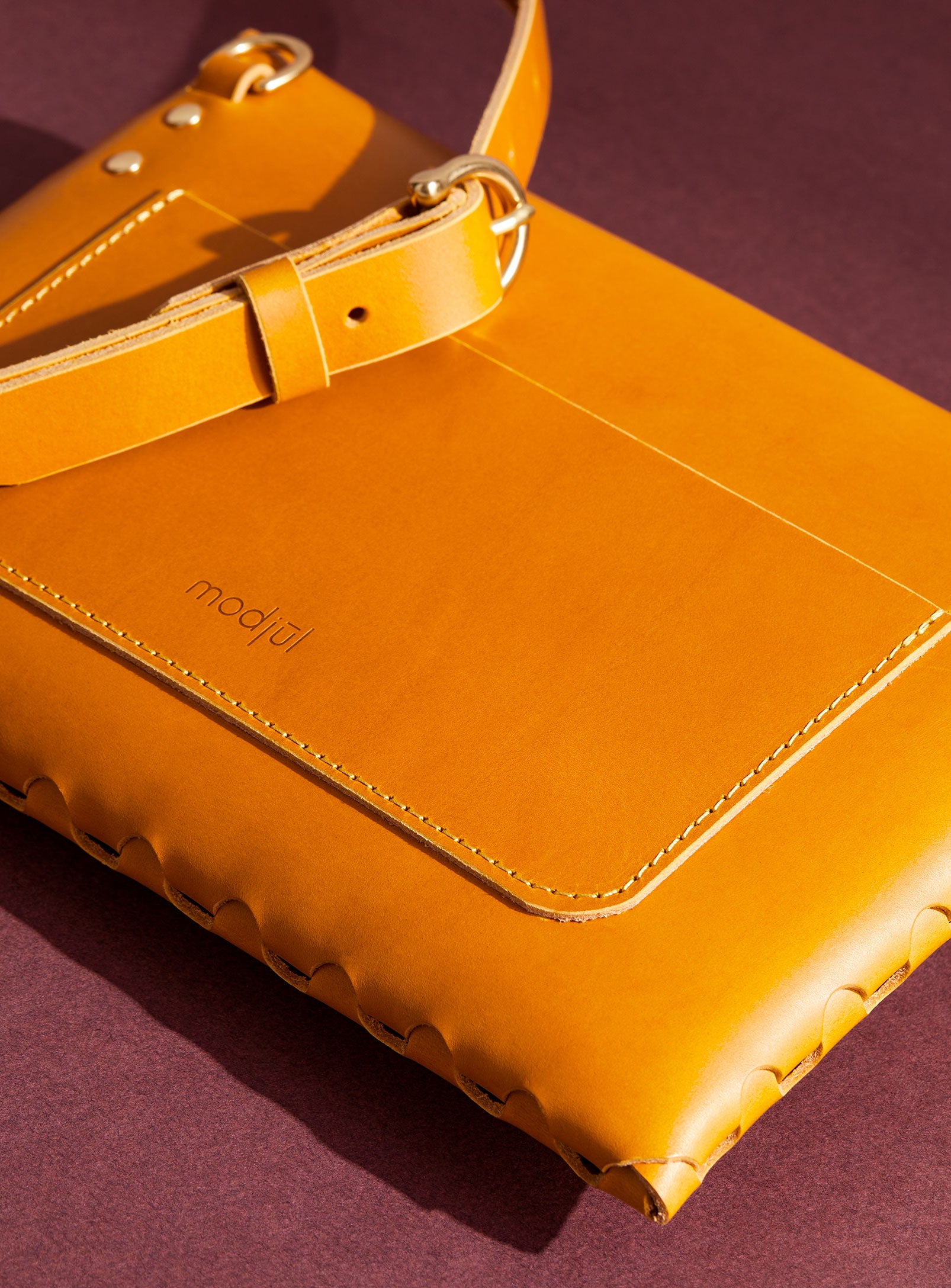 A close up of the back pocket detail on the mini bag deluxe handcrafted in Canada using yellow Italian leather and quality brass hardware.
