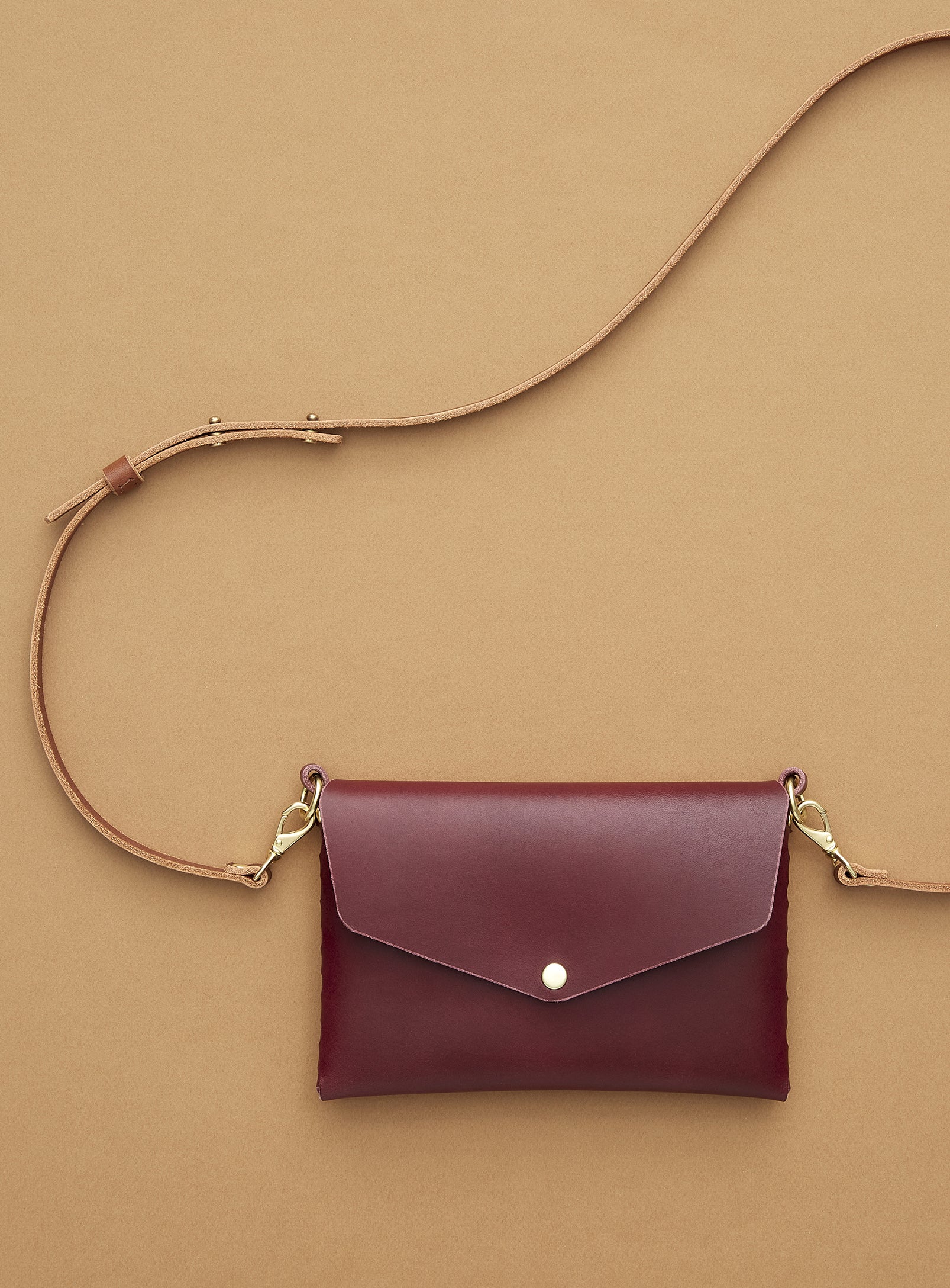 modjūl's mini leather bag in burgundy. A rectangular-shaped bag with long straps, handmade in Canada using quality Italian leather and brass hardware.