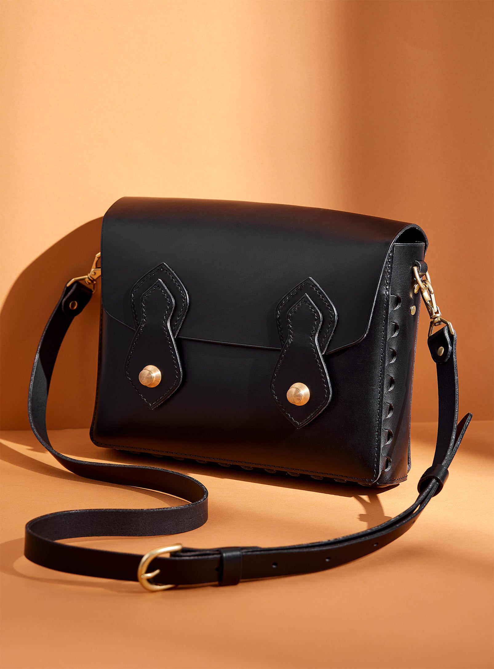 The modjūl odyssey bag in black. A large side bag with crossbody straps and double brass closure. Handcrafted in Canada using vegetable dyed Italian leather and quality brass hardware.