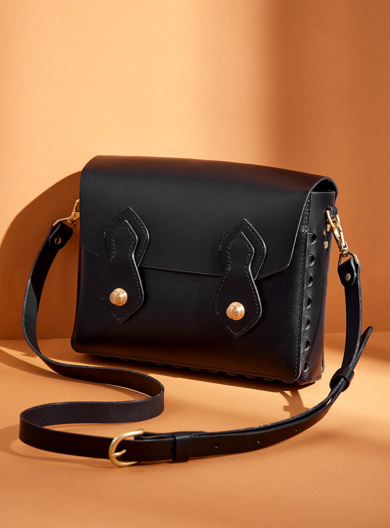 The modjūl odyssey bag in black. A large side bag with crossbody straps and double brass closure. Handcrafted in Canada using vegetable dyed Italian leather and quality brass hardware. 
