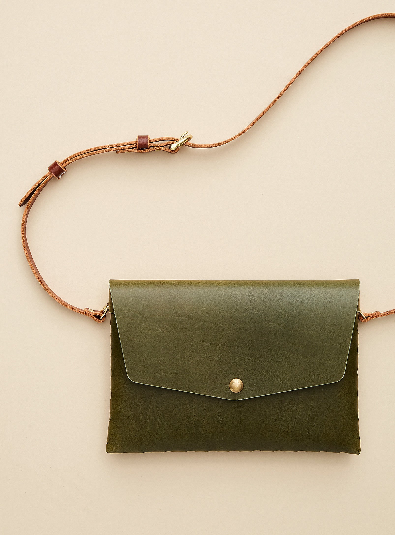 modjūl’s leather mini bag deluxe bag in olive. A larger take on the classic mini bag, a rectangular-shaped bag with long detachable straps, handcrafted in Canada using quality Italian leather and brass hardware.