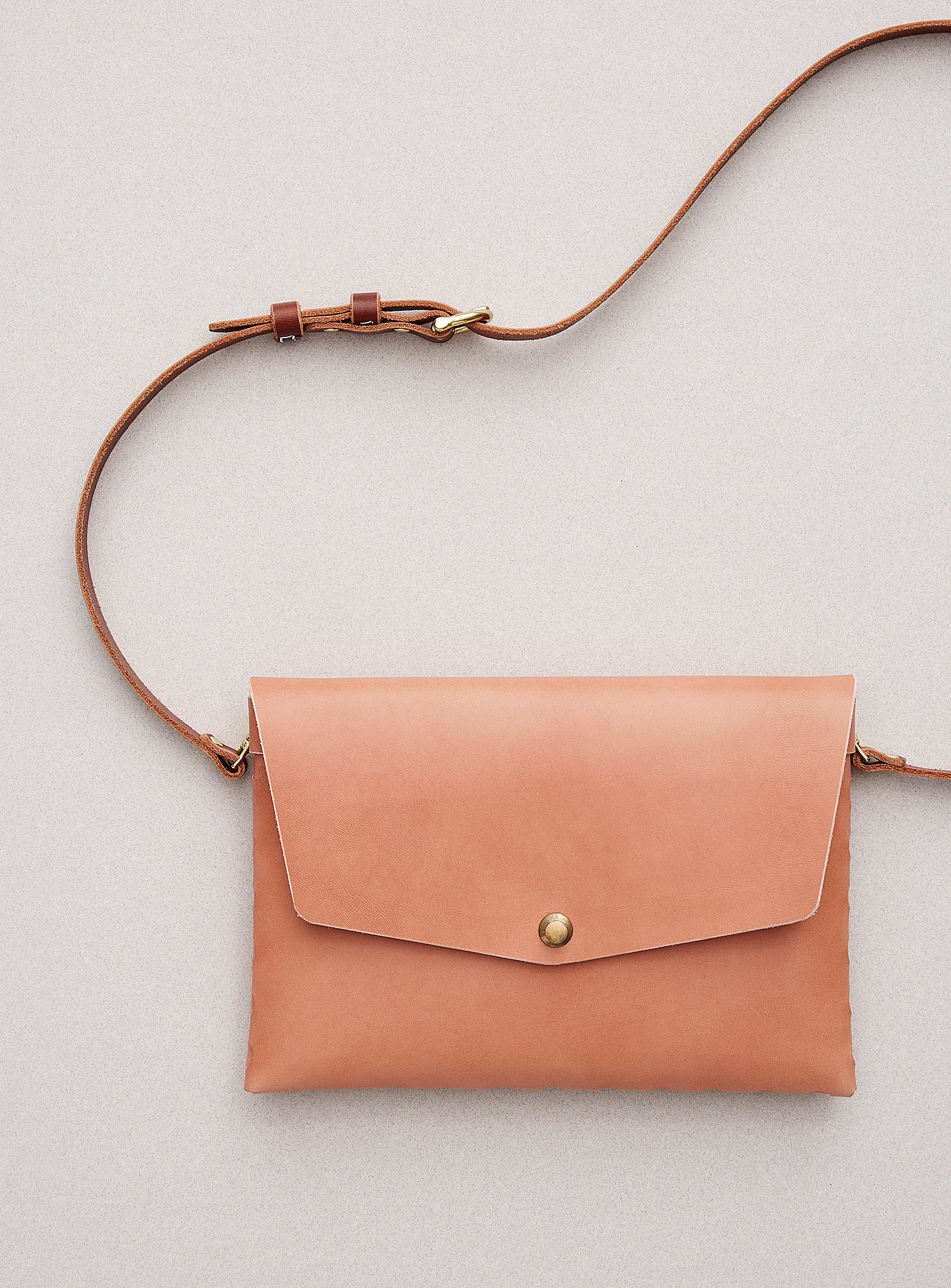 modjūl’s leather mini bag deluxe bag in pink. A larger take on the classic mini bag, a rectangular-shaped bag with long detachable straps, handcrafted in Canada using quality Italian leather and brass hardware.