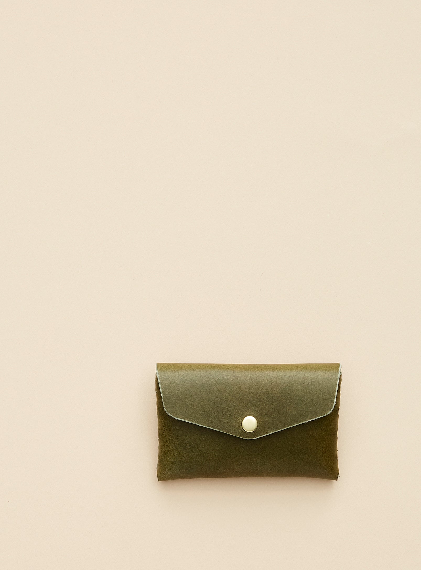 modjūl's classic pouch in olive colored leather. A compact open wallet with endless possibilities, perfect for holding cards, keys or loose change. Handmade in Canada and joined with the signature modjūl joinery and quality brass hardware.