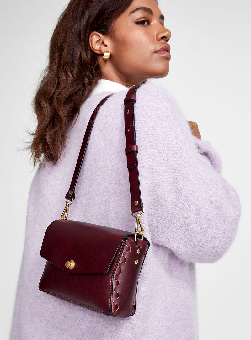 A woman wearing the burgundy leather petite crossbody, handmade by modjūl in Canada.