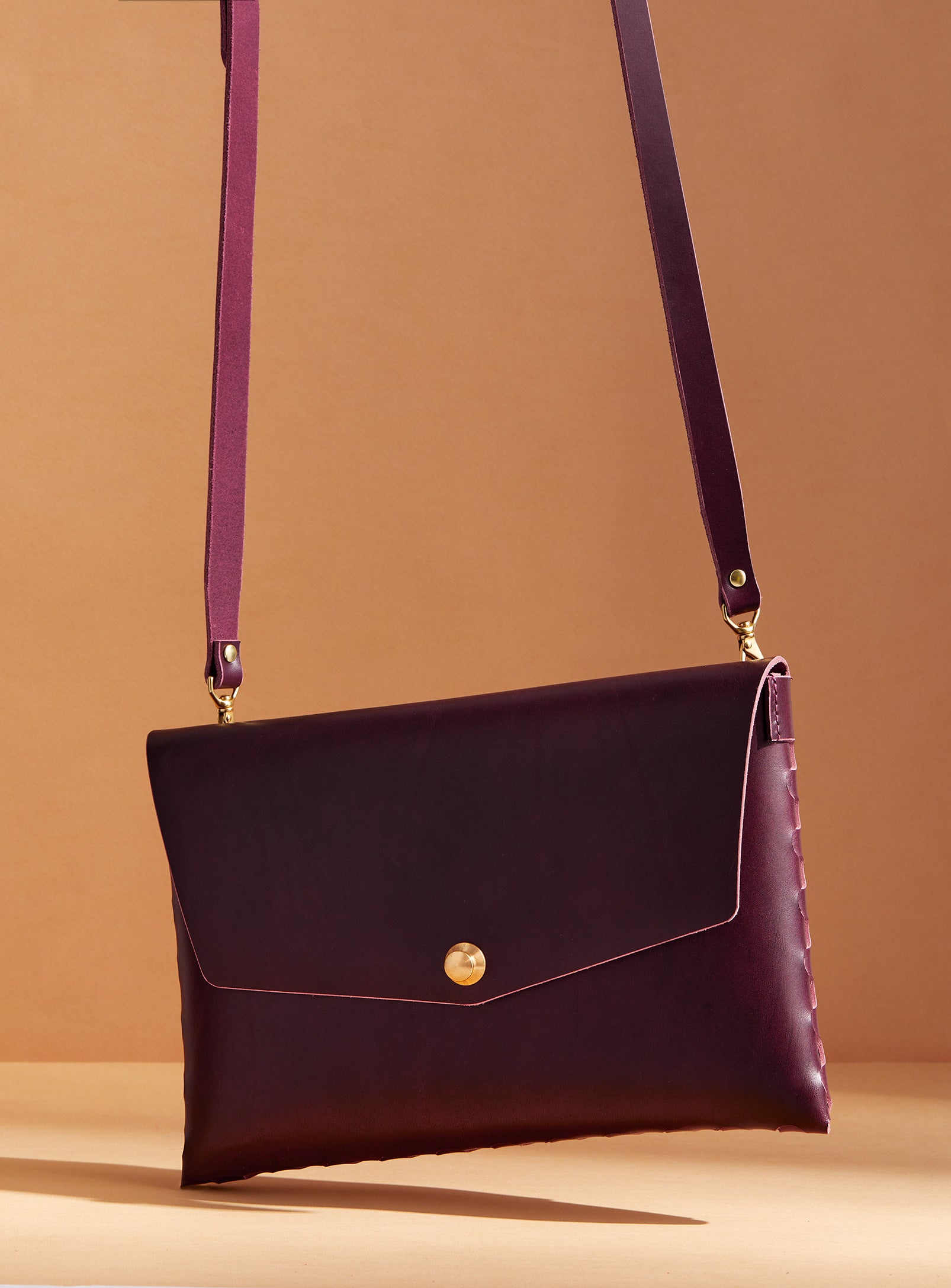 modjūl’s leather mini bag deluxe bag in burgundy. A larger take on the classic mini bag, a rectangular-shaped bag with long detachable straps, handcrafted in Canada using quality Italian leather and brass hardware.