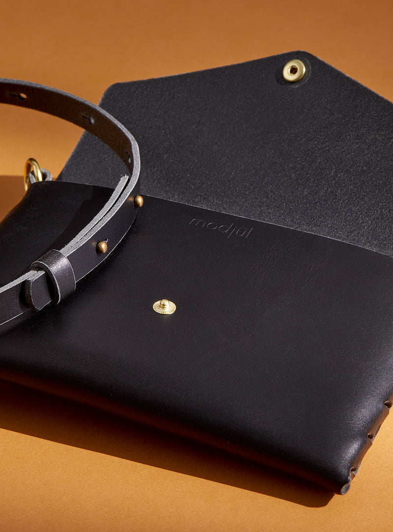 modjūl's mini leather bag in black. A rectangular-shaped bag with long straps, handmade in Canada using quality Italian leather and brass hardware.