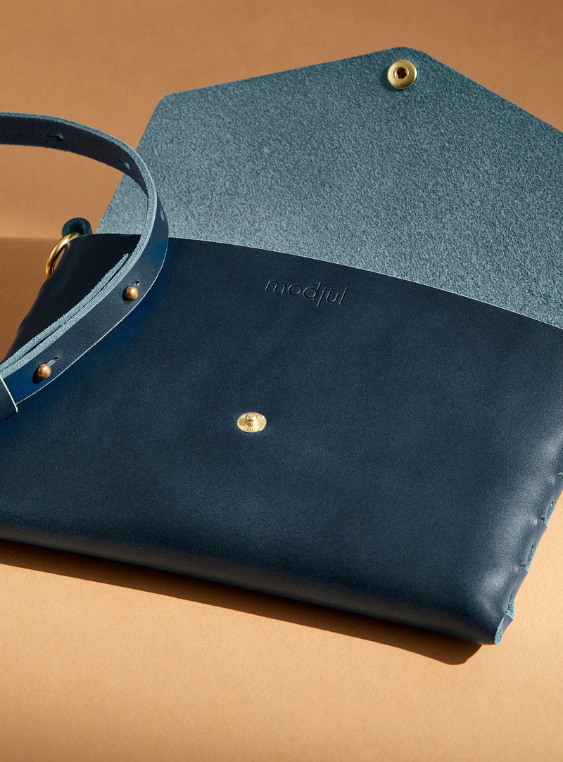An inside view of modjūl's mini leather bag in blue. A rectangular-shaped bag with long straps, handmade in Canada using quality Italian leather and brass hardware.