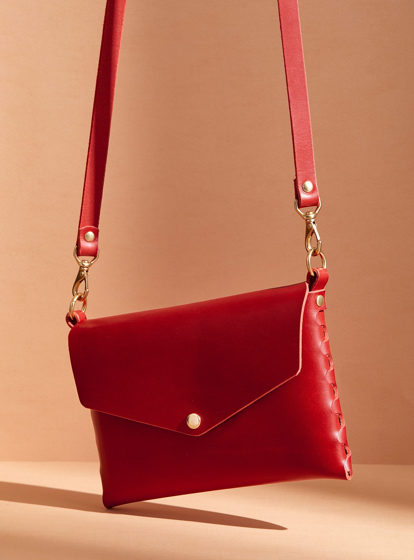 The modjūl mini bag in red. A classic leather bag handmade in Canada using quality leather and brass hardware.