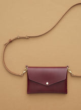 modjūl's mini leather bag in burgundy. A rectangular-shaped bag with long straps, handmade in Canada using quality Italian leather and brass hardware.