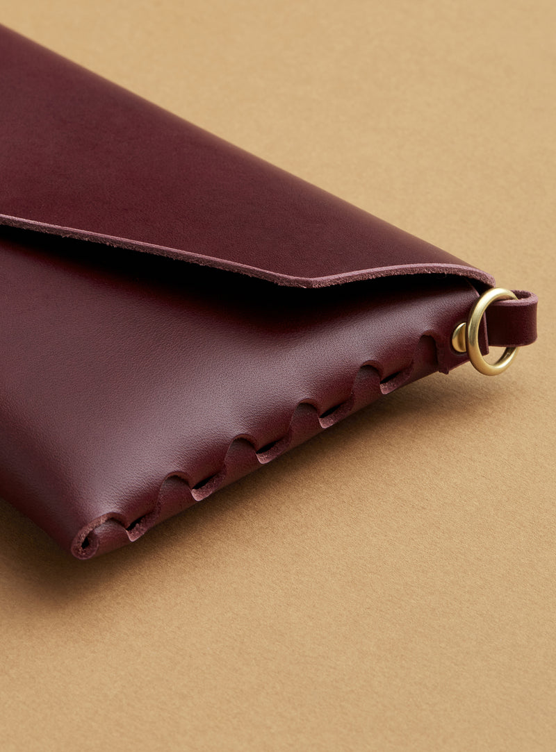 A closeup of modjūl's signature joinery on the leather mini bag in burgundy. Handcrafted from Italian leather and quality brass hardware in Canada.