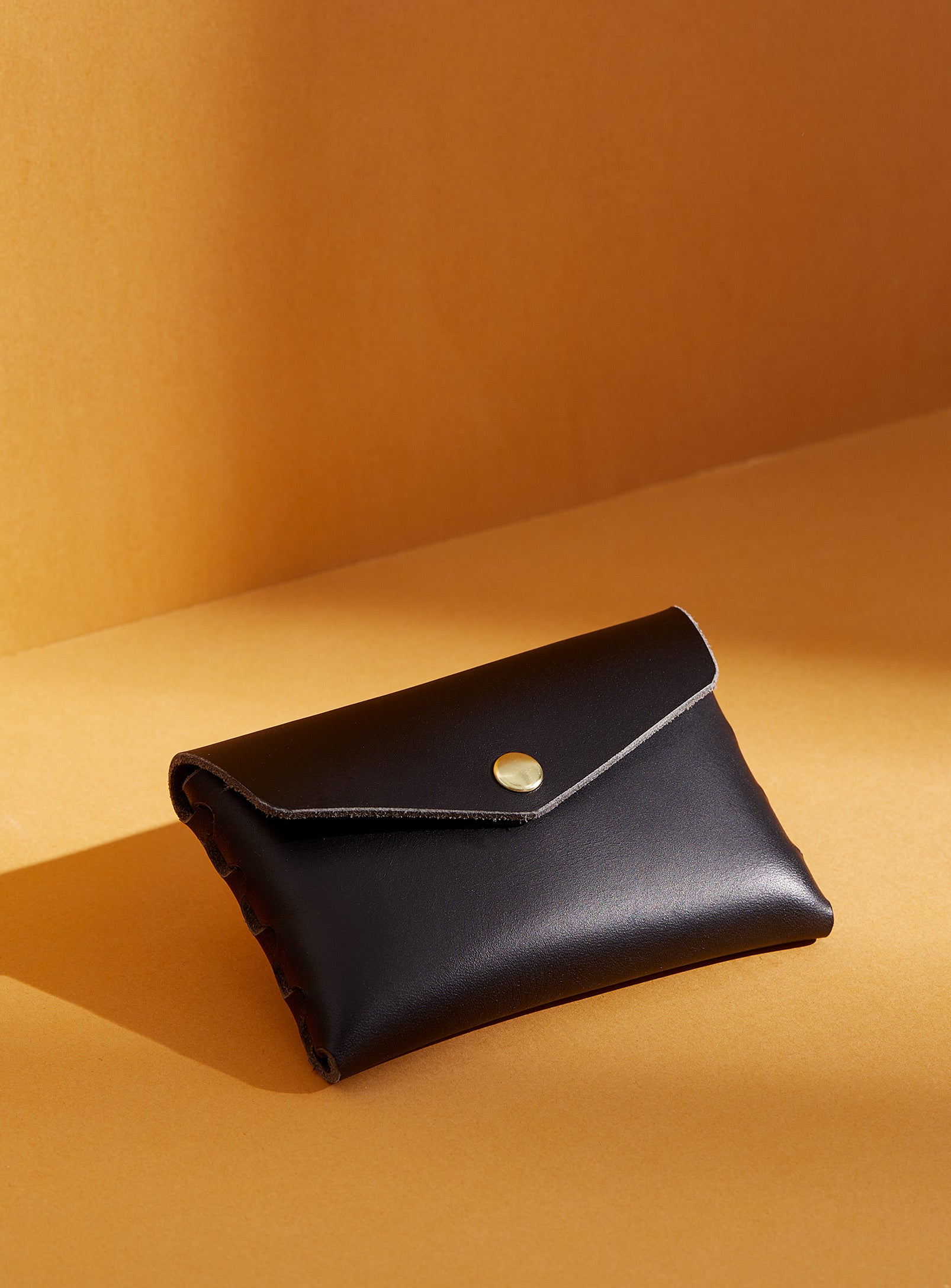 modjūl's classic pouch in black leather. A compact open wallet with endless possibilities, perfect for holding cards, keys or loose change. Handmade in Canada and joined with the signature modjūl joinery and quality brass hardware.