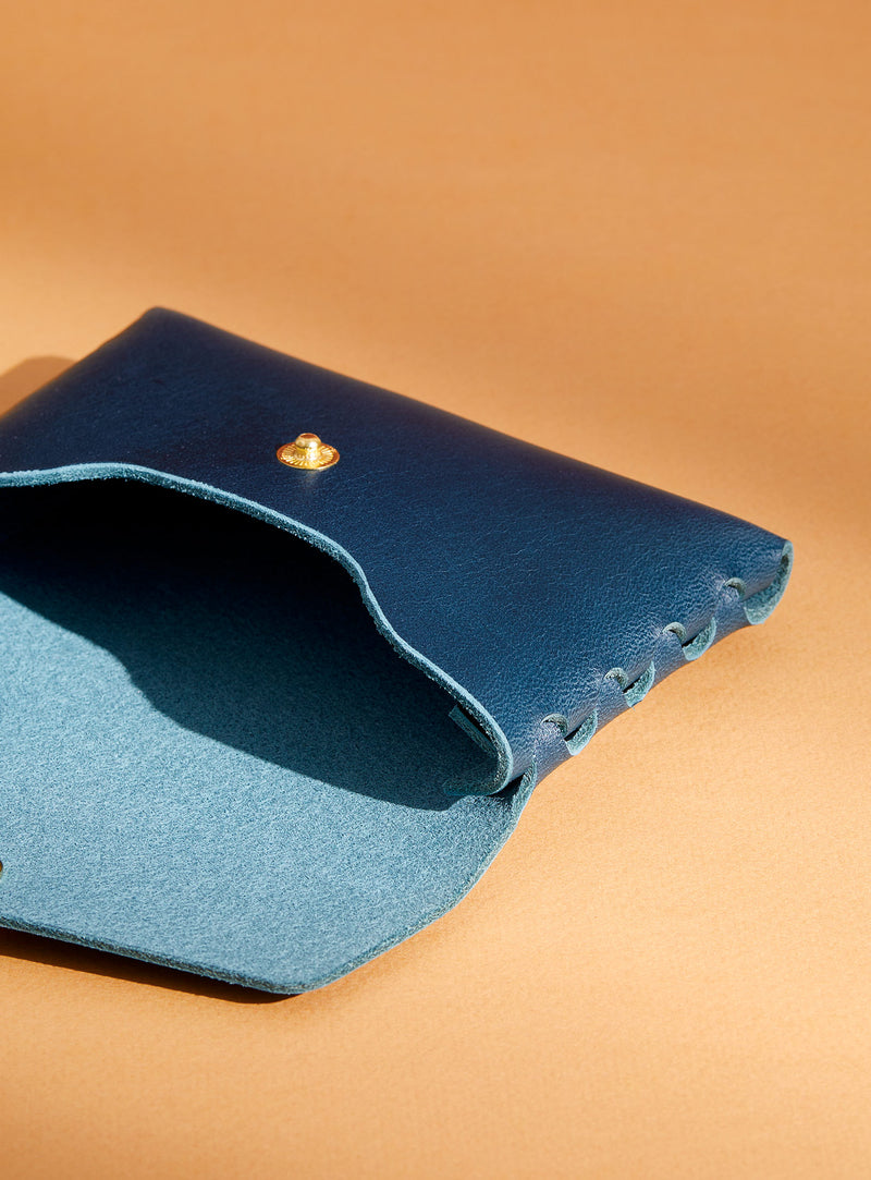 An inside look at modjūl's classic pouch in blue leather. A compact open wallet with endless possibilities, perfect for holding cards, keys or loose change. Handmade in Canada and joined with the signature modjūl joinery and quality brass hardware.