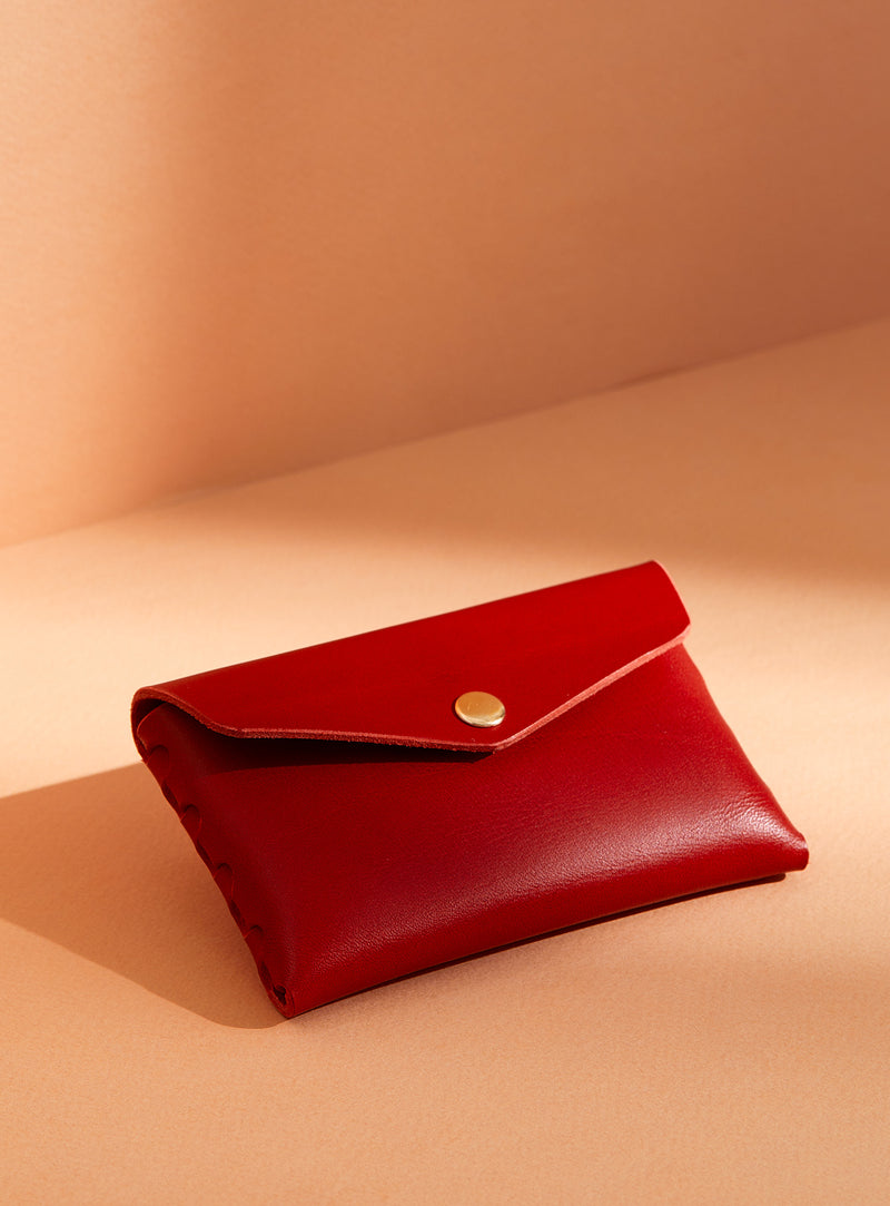 modjūl's classic pouch in red leather. A compact open wallet with endless possibilities, perfect for holding cards, keys or loose change. Handmade in Canada and joined with the signature modjūl joinery and quality brass hardware.