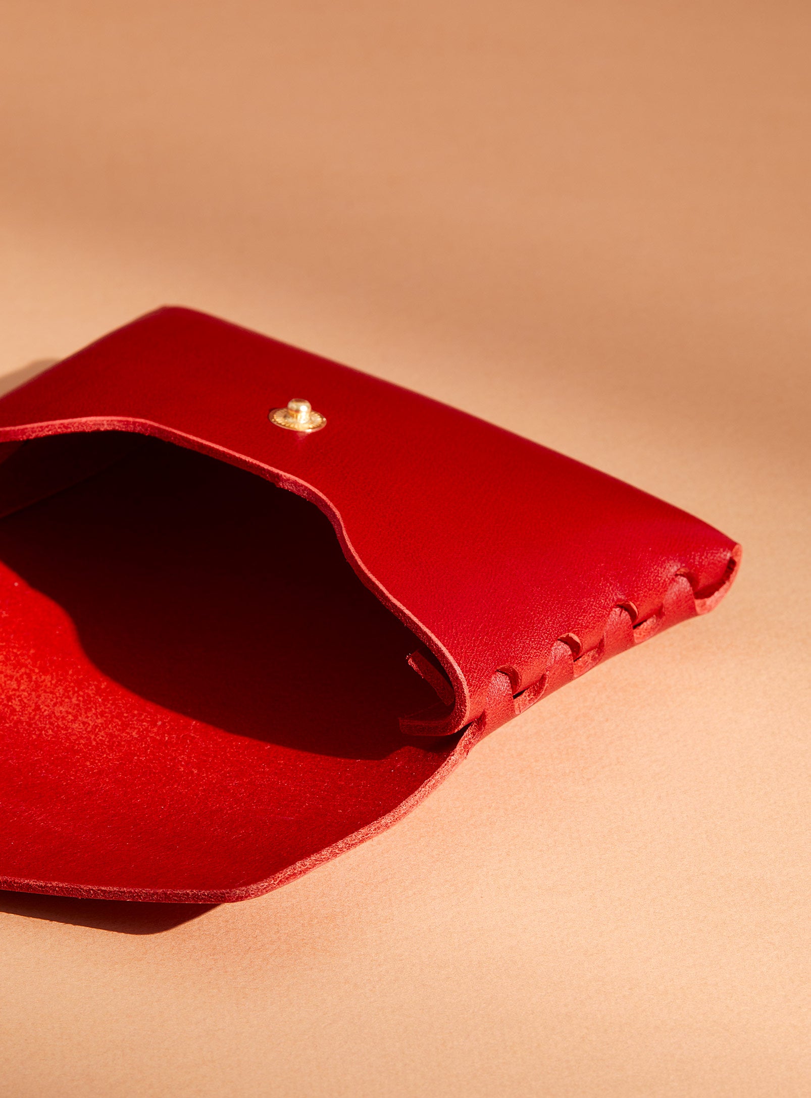 An inside look at modjūl's classic pouch in red leather. A compact open wallet with endless possibilities, perfect for holding cards, keys or loose change. Handmade in Canada and joined with the signature modjūl joinery and quality brass hardware.