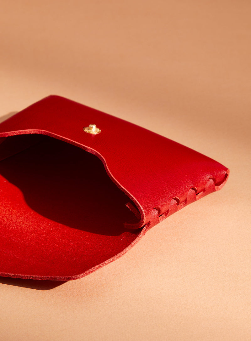 An inside look at modjūl's classic pouch in red leather. A compact open wallet with endless possibilities, perfect for holding cards, keys or loose change. Handmade in Canada and joined with the signature modjūl joinery and quality brass hardware.