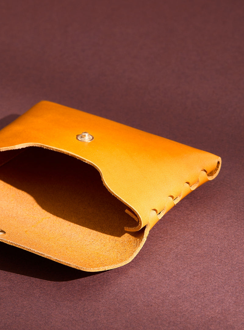 An inside view of modjūl's classic pouch in yellow leather. A compact open wallet with endless possibilities, perfect for holding cards, keys or loose change. Handmade in Canada and joined with the signature modjūl joinery and quality brass hardware.