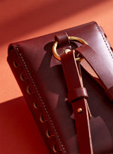 A close-up of the back of modjūl's leather capsule bag in brown. 