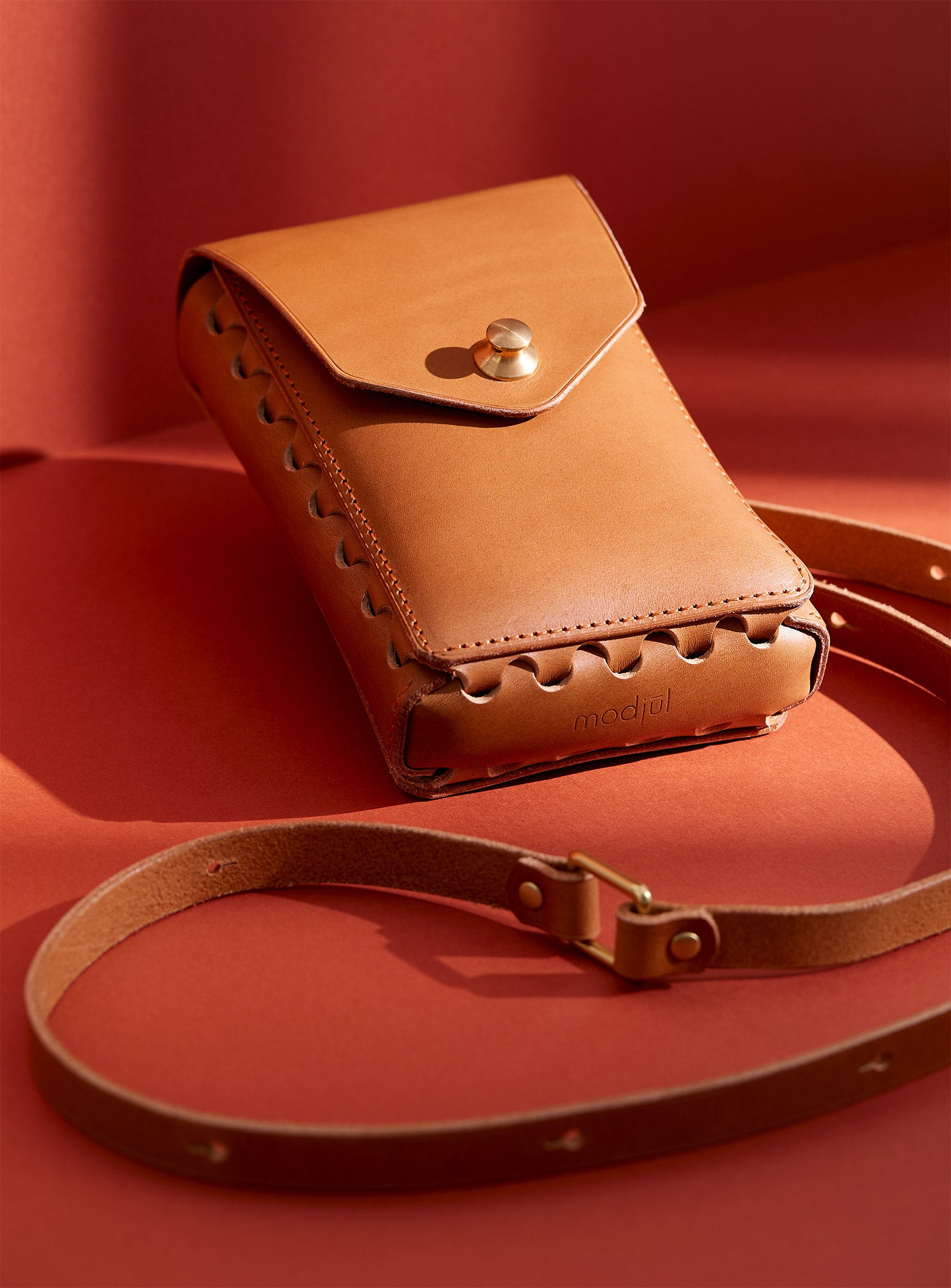 modjūl's capsule leather bag in camel. A rectangular-shaped bag with long straps, the perfect bag for a phone.