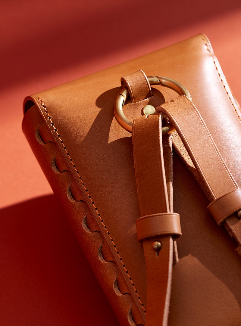 A close-up of the back of modjūl's leather capsule bag in camel. Handmade in Canada.