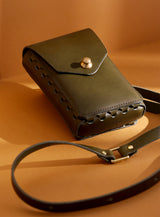 modjūl's capsule leather bag in olive. A rectangular-shaped bag with long straps, perfect for a phone.