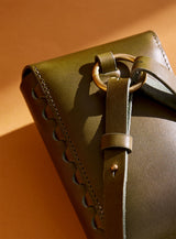 A close-up of the back of modjūl's leather capsule bag in olive.