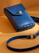 modjūl's capsule leather bag in blue. A rectangular-shaped bag with long straps, perfect for a phone.