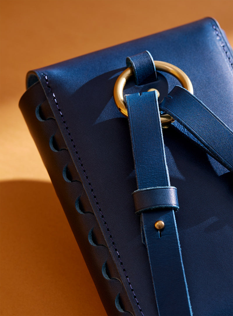 A close-up of the back of modjūl's leather capsule bag in blue.