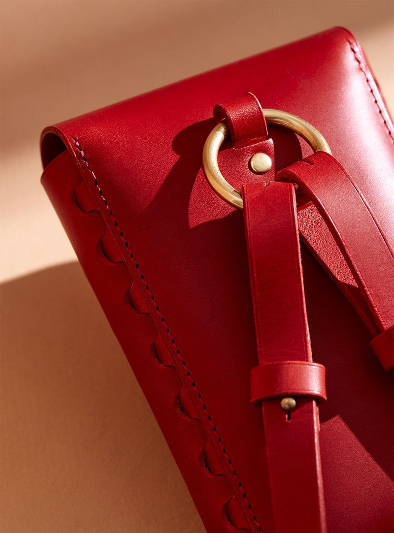A close-up of the back of modjūl's leather capsule bag in red.