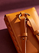 Close up of the modjūl capsule leather bag in yellow, showcasing hardware and strap attachment.