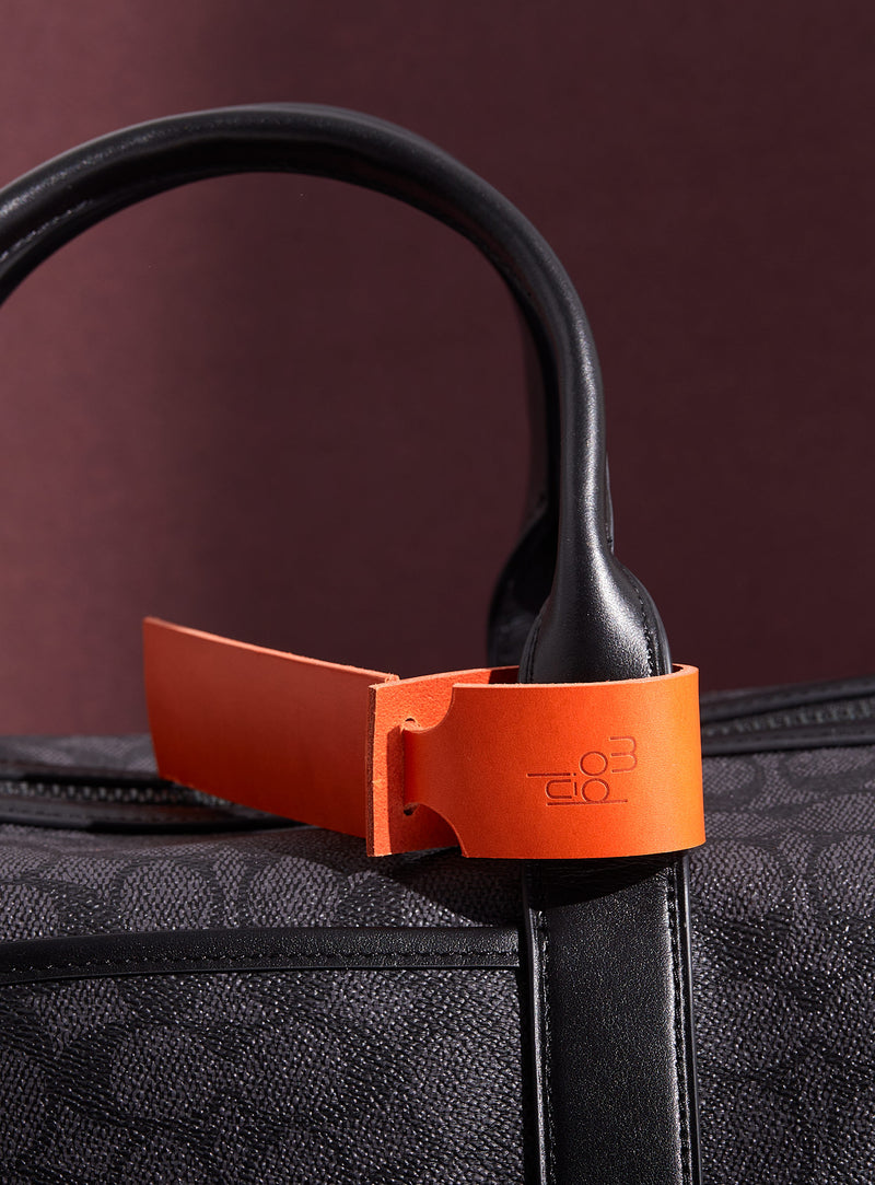 The modjūl leather traveller’s tag in orange. A luggage tag constructed using quality vegetable-dyed Italian leather with the option for personalization.