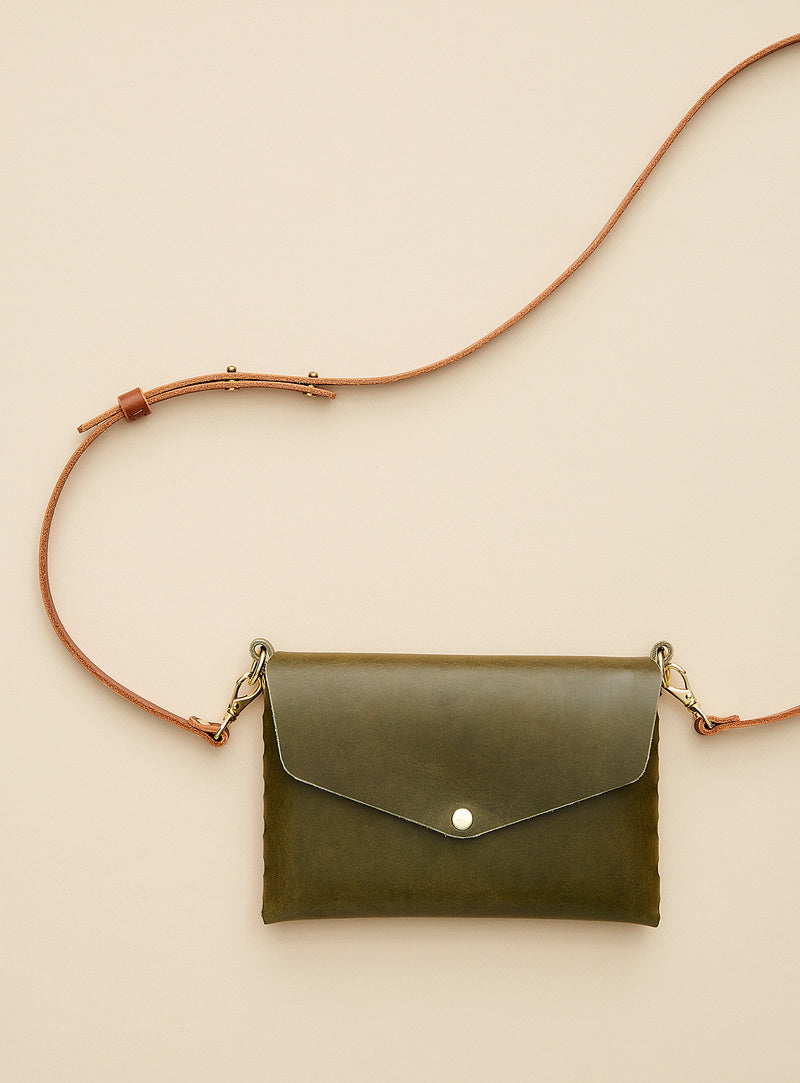modjūl's mini leather bag in olive. A rectangular-shaped bag with long straps, handmade in Canada using quality Italian leather and brass hardware.