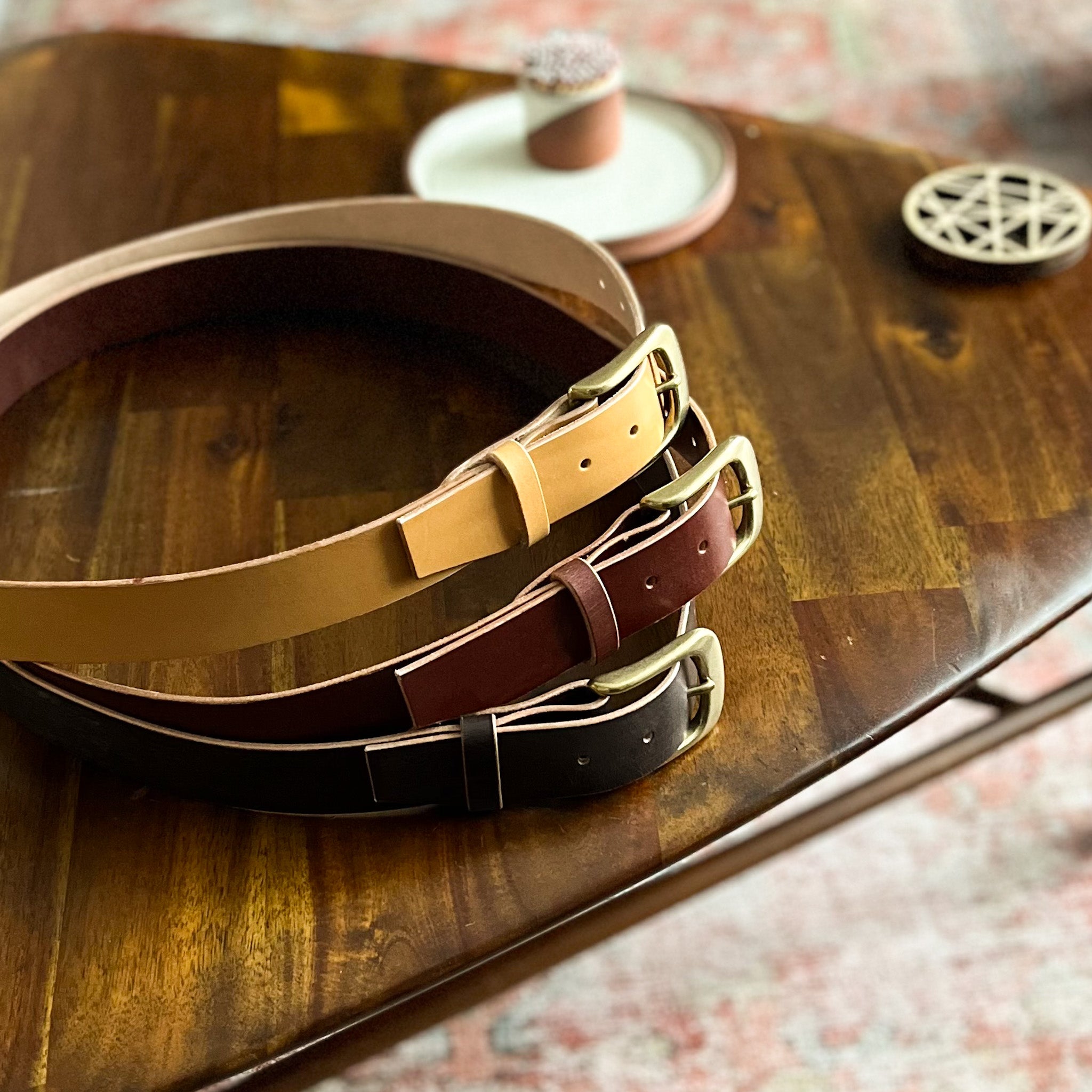modjūl premium leather belts stacked on top of one another. Handmade in Canada using Italian leather and quality hardware.