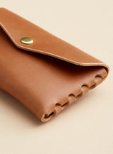 A side profile of modjūl's classic pouch in camel colored leather. A compact open wallet with endless possibilities, perfect for holding cards, keys or loose change. Handmade in Canada and joined with the signature modjūl joinery and quality brass hardware.
