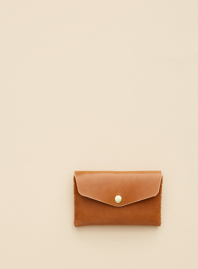 modjūl's classic pouch in camel colored leather. A compact open wallet with endless possibilities, perfect for holding cards, keys or loose change. Handmade in Canada and joined with the signature modjūl joinery and quality brass hardware.